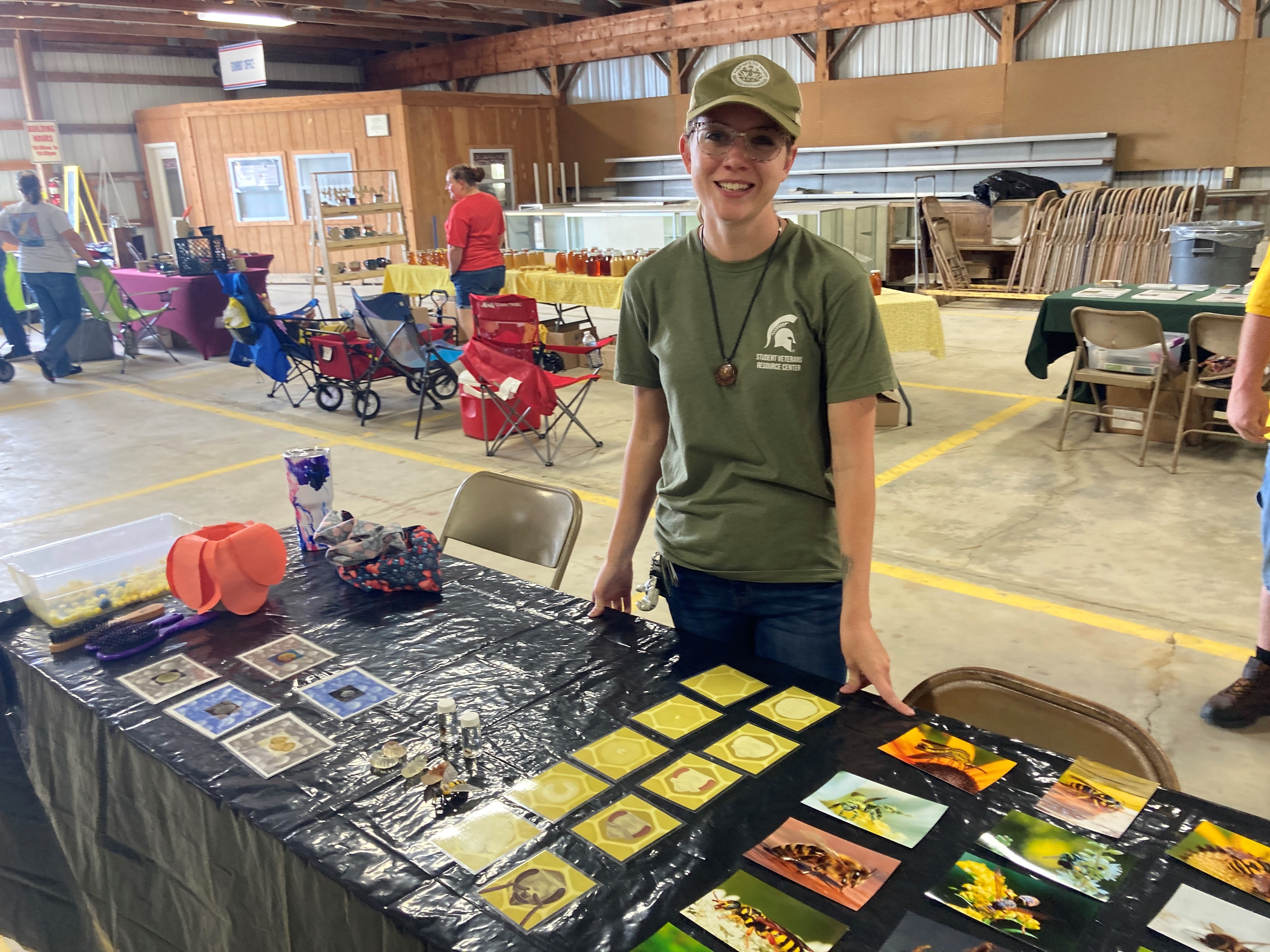 Photo of Sarah behind a table with activities at a fair.